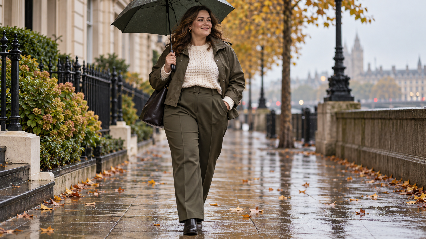 Plus-size woman wearing olive tailored trousers, a cream knit and cropped waterproof jacket in light autumn rain.